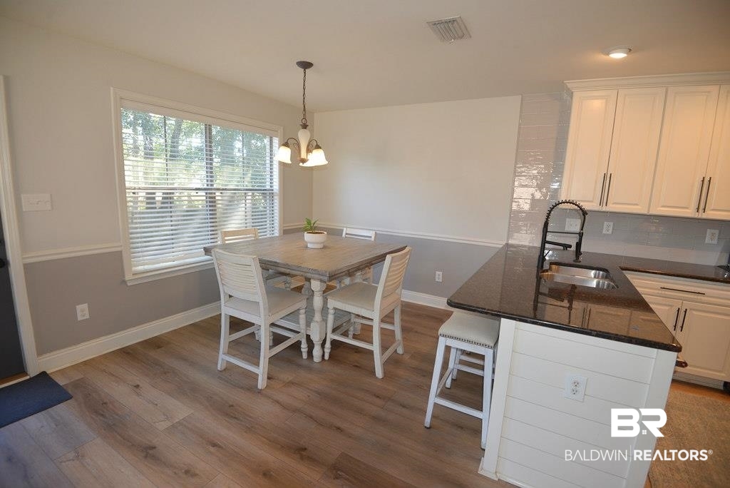 11201 Herschel Loop Daphne, AL 36526 - Photo 5 of 32 Dining room with sink, a notable chandelier, and light hardwood / wood-style flooring