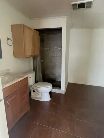 a bathroom with a sink a toilet and shower
