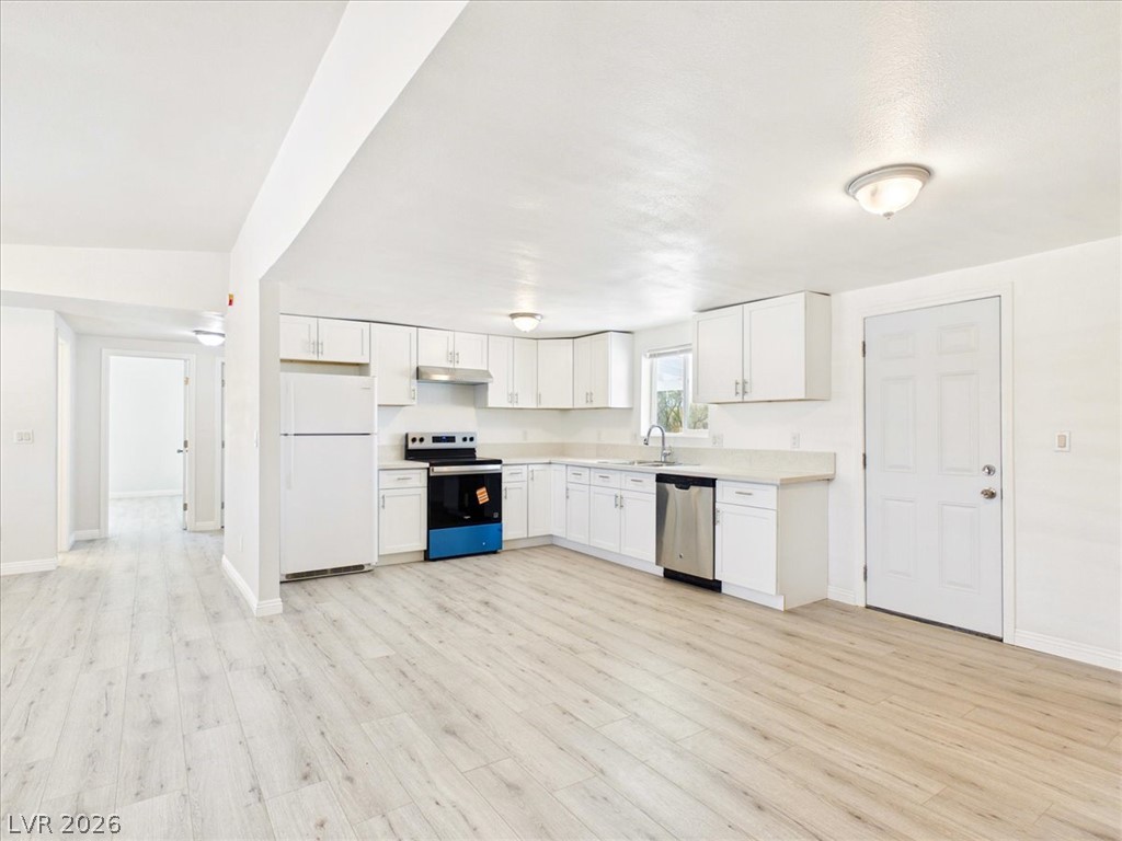 4081 Retread Road Pahrump, NV 89048 - Photo 24 of 98 A well-lit kitchen presents bright cabinetry, stainless steel appliances, and sleek laminate flooring.