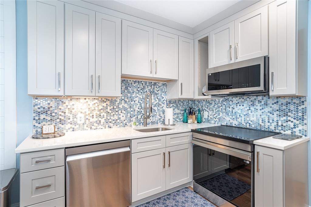 6005 North Beach Road, Unit 16 Englewood, FL 34223 - Photo 11 of 57 a kitchen with white cabinets sink and stove