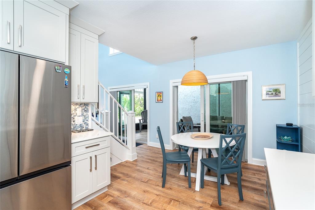 6005 North Beach Road, Unit 16 Englewood, FL 34223 - Photo 13 of 57 a dining room with furniture a chandelier and wooden floor