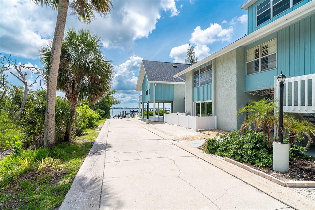 6005 North Beach Road, Unit 16 Englewood, FL 34223 - Photo 2 of 57 a front view of a house with a yard and potted plants