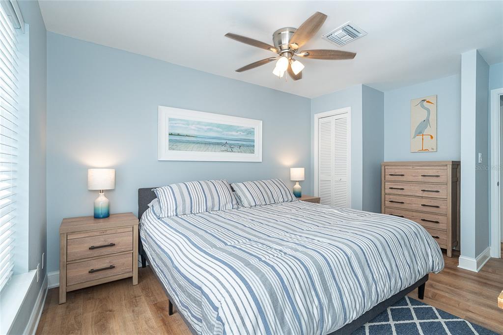 6005 North Beach Road, Unit 16 Englewood, FL 34223 - Photo 22 of 57 a bedroom with a bed a lamp and a chandelier