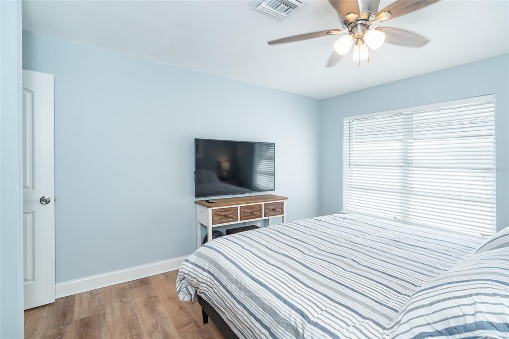 6005 North Beach Road, Unit 16 Englewood, FL 34223 - Photo 24 of 57 a bedroom with a bed and a flat screen tv