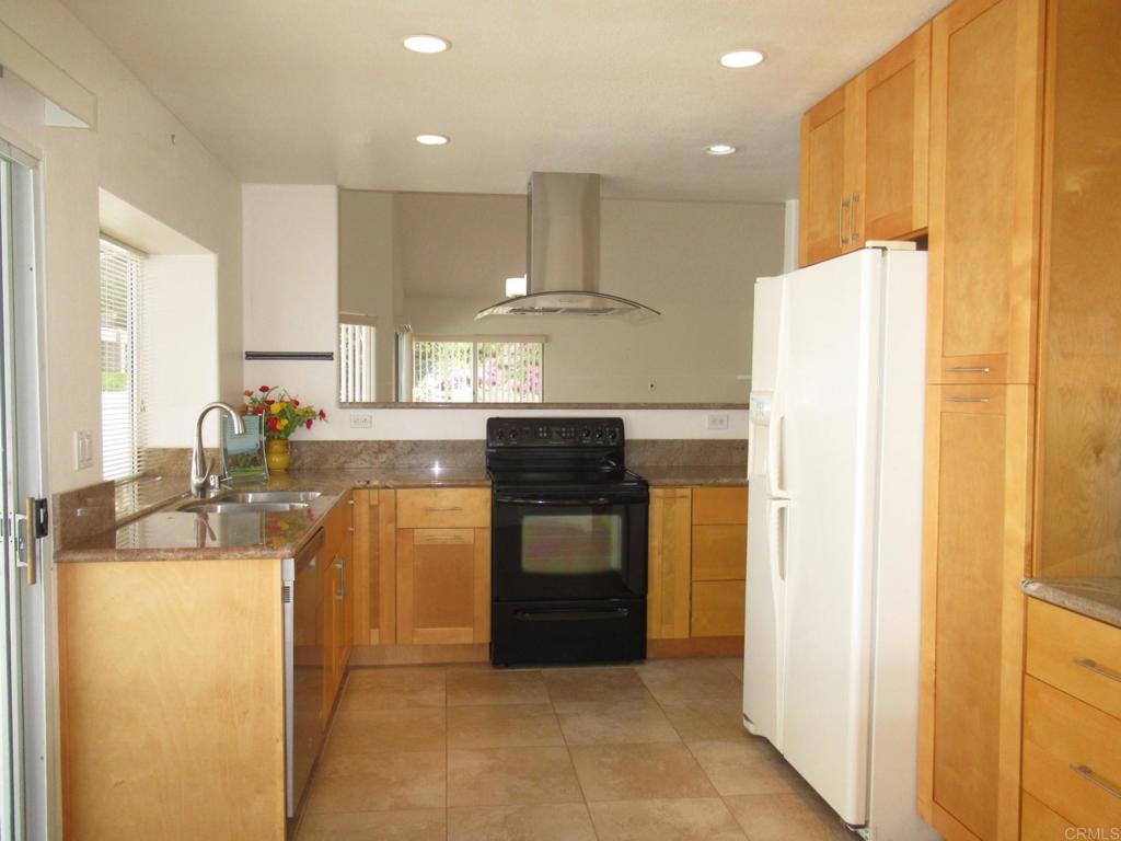 a kitchen with kitchen island a counter top space stainless steel appliances and a window