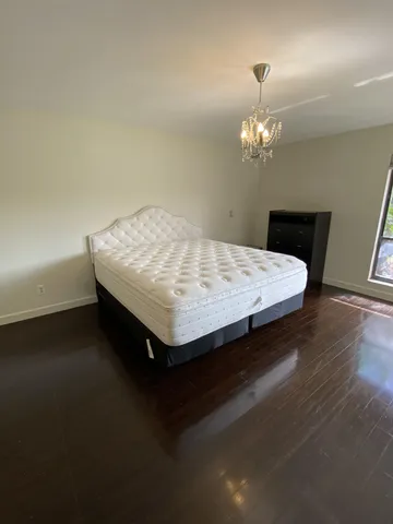 a bedroom with a large bed and a chandelier