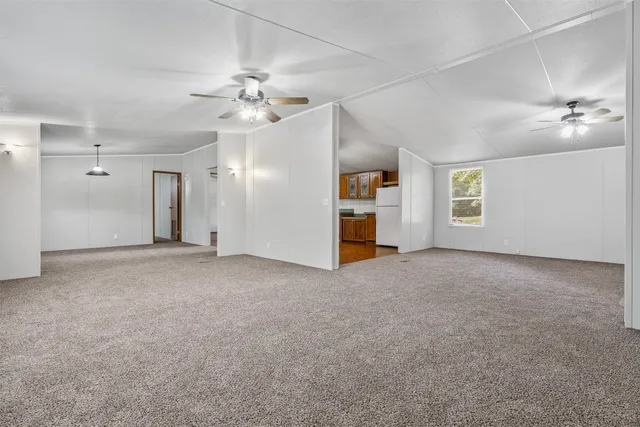 a view of a big room with chandelier fan and windows