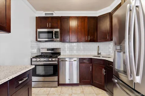 a kitchen with stainless steel appliances granite countertop a stove microwave and sink