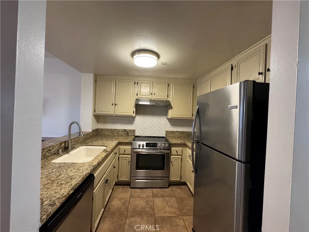 730 West 4th Street Long Beach, CA 90802 - Photo 17 of 35 a kitchen with granite countertop kitchen island stainless steel appliances a refrigerator a stove a sink and a refrigerator