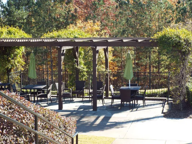 a view of house with wooden fence and a large tree