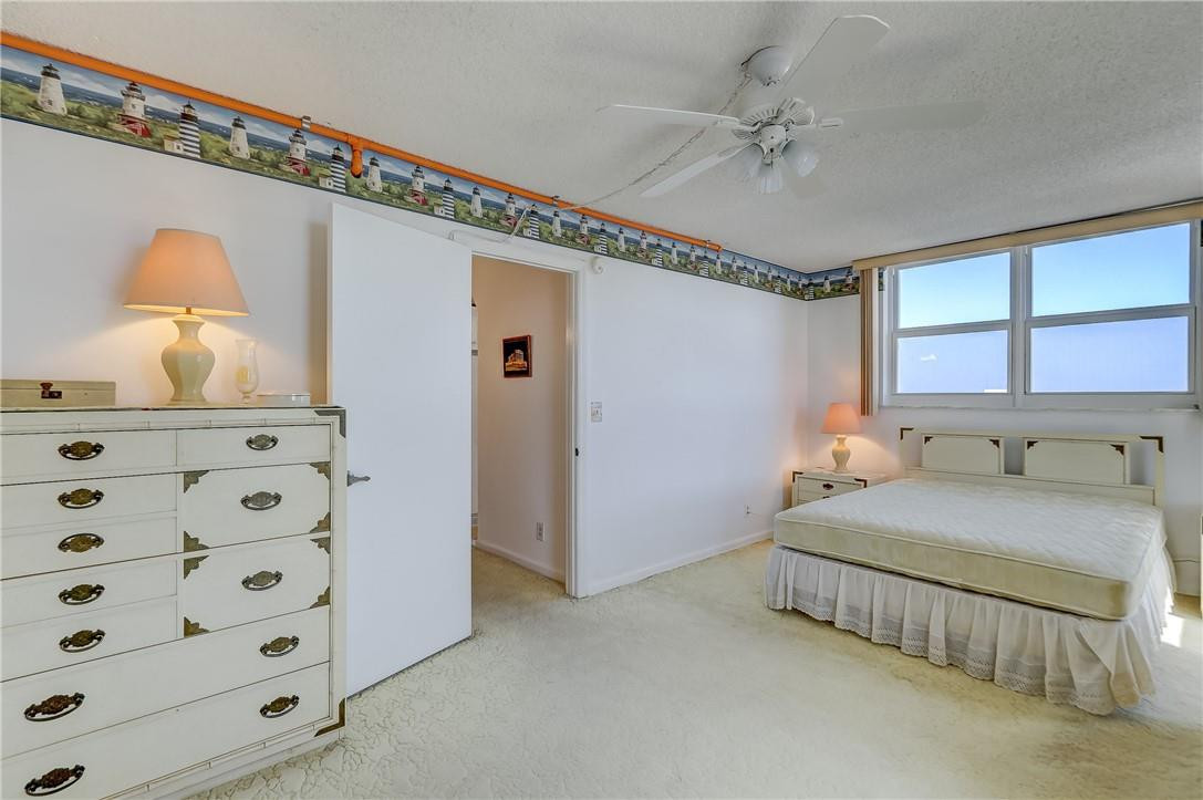 1505 North Riverside Drive, Unit 1208 Pompano Beach, FL 33062 - Photo 31 of 62 a bedroom with a bed and a chandelier