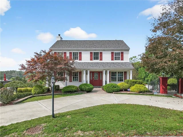 a front view of a house with a yard and trees