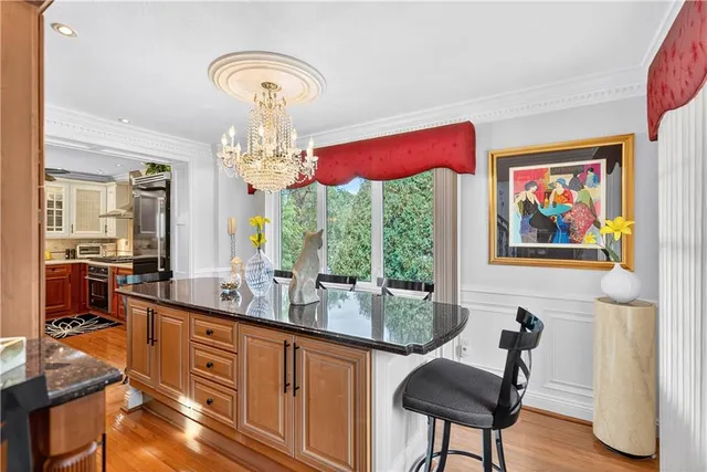 a very nice looking dining room with furniture a chandelier and a large window