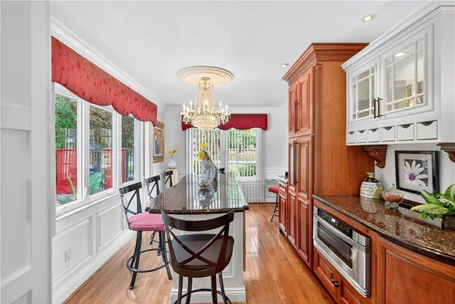 a very nice looking dining room with furniture a chandelier and a large window