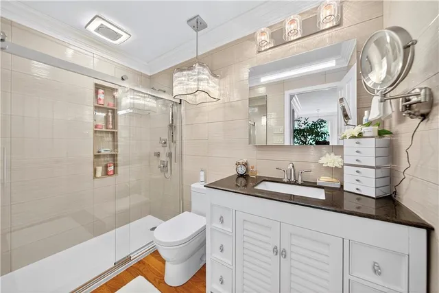 a bathroom with a double vanity sink toilet mirror and shower