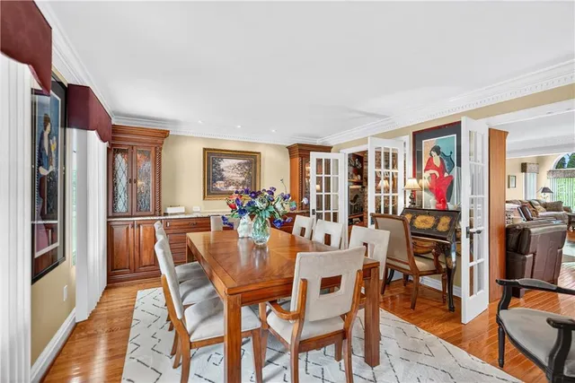 a dining room with furniture wooden floor a potted plant and a painting
