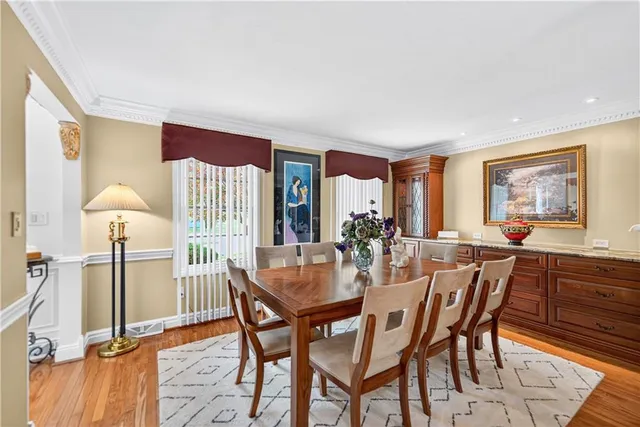 a dining room with furniture a painting and a potted plant