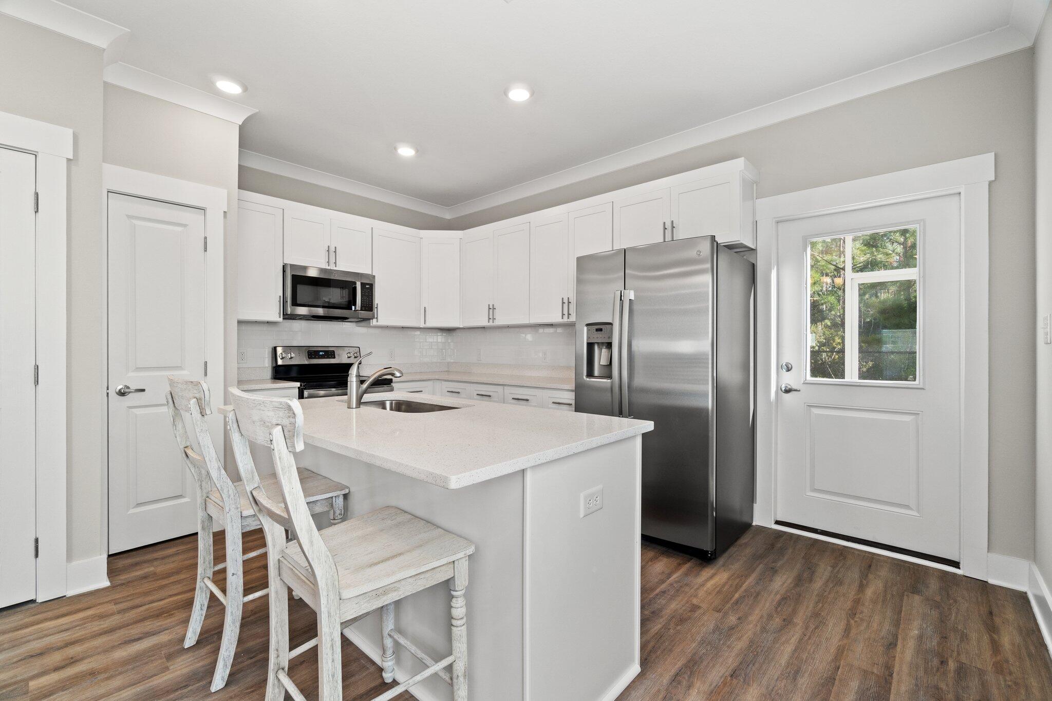 274 Date Palm Lane, Unit HORIZON Freeport, FL 32439 - Photo 10 of 28 a kitchen with kitchen island a refrigerator stove microwave and cabinets
