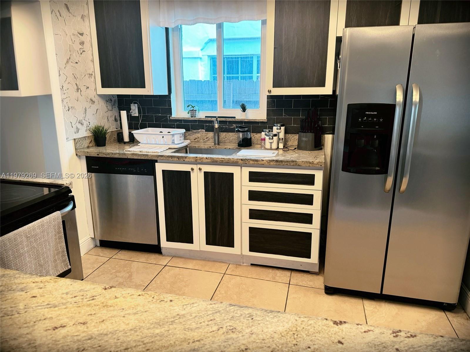 4734 Southwest 4th Street Miami, FL 33134 - Photo 2 of 23 a kitchen with stainless steel appliances kitchen island granite countertop a sink stove and refrigerator