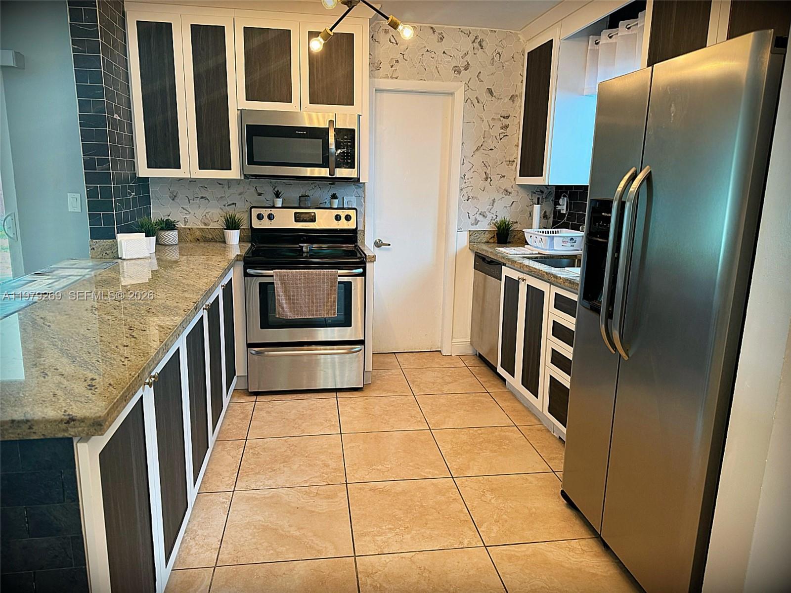 4734 Southwest 4th Street Miami, FL 33134 - Photo 5 of 23 a kitchen with granite countertop a refrigerator and a stove