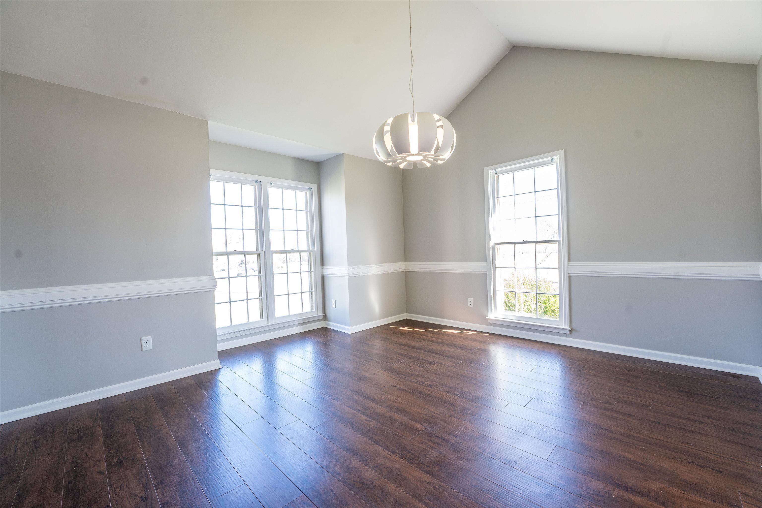 8747 Walnut Grove Road Memphis, TN 38018 - Photo 3 of 25 an empty room with wooden floor and windows