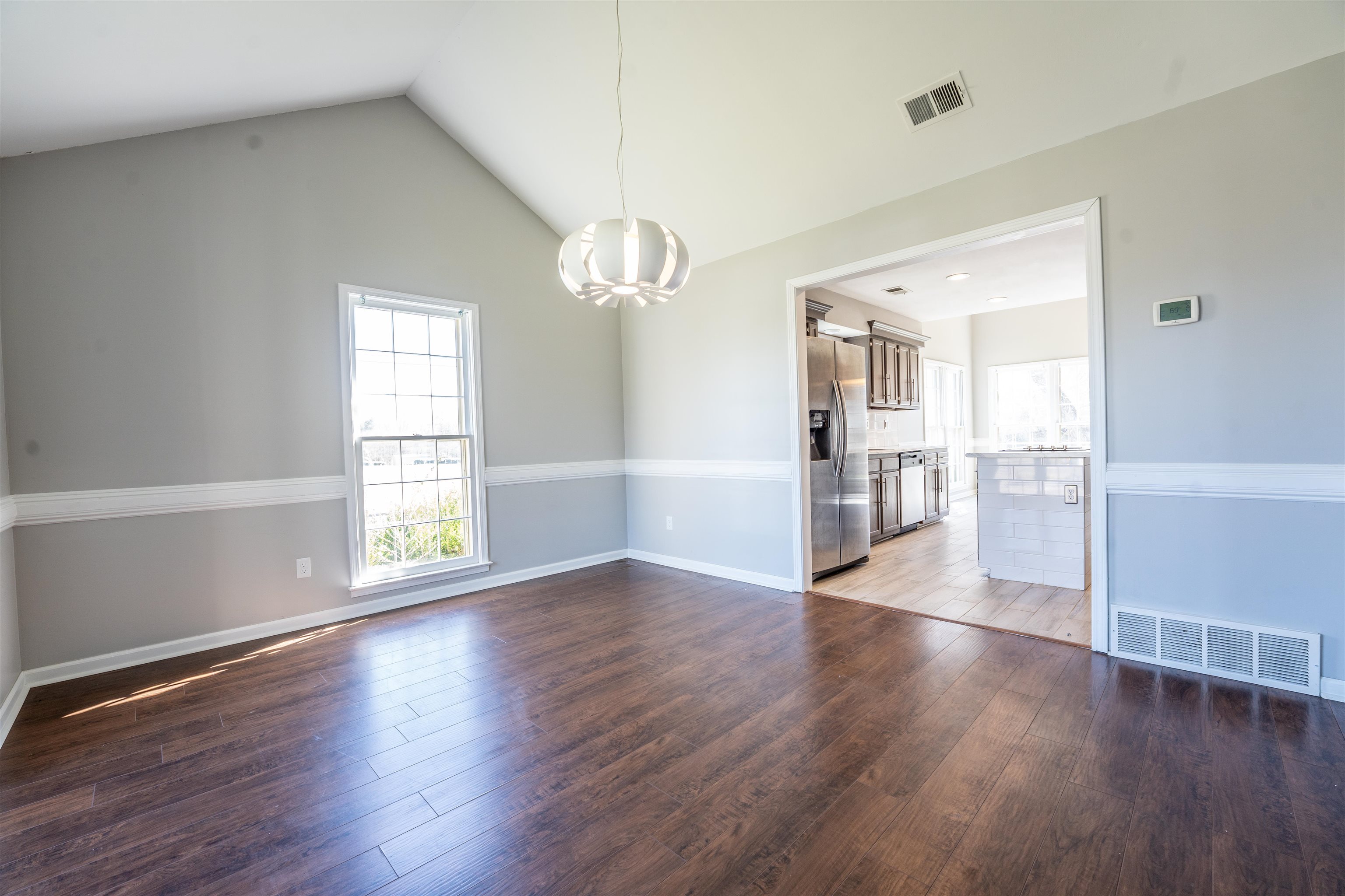 8747 Walnut Grove Road Memphis, TN 38018 - Photo 4 of 25 an empty room with wooden floor and windows