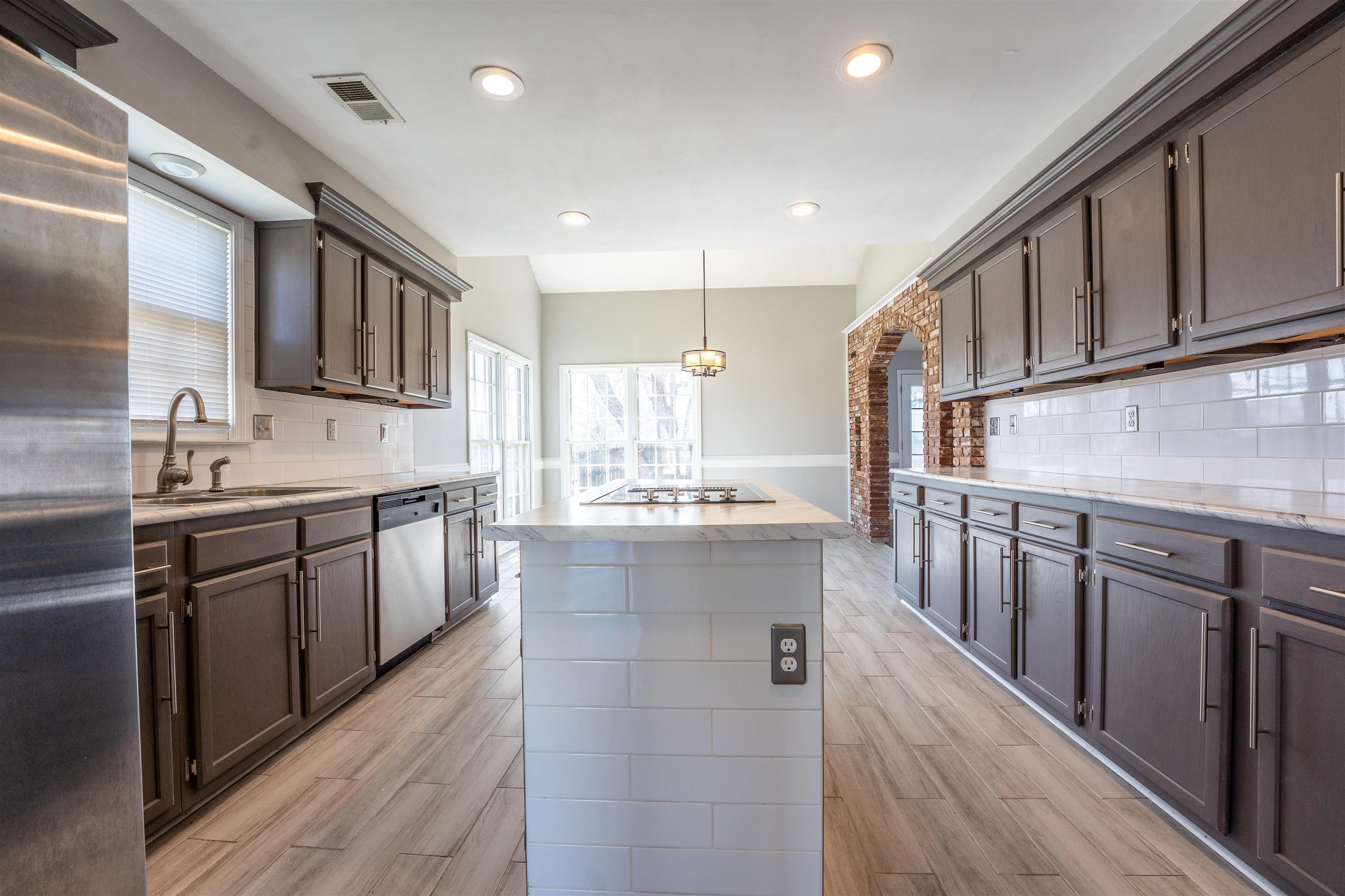 8747 Walnut Grove Road Memphis, TN 38018 - Photo 6 of 25 a kitchen with stainless steel appliances granite countertop a sink stove and cabinets