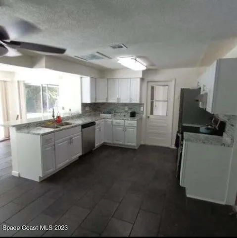 a kitchen with sink cabinets and refrigerator
