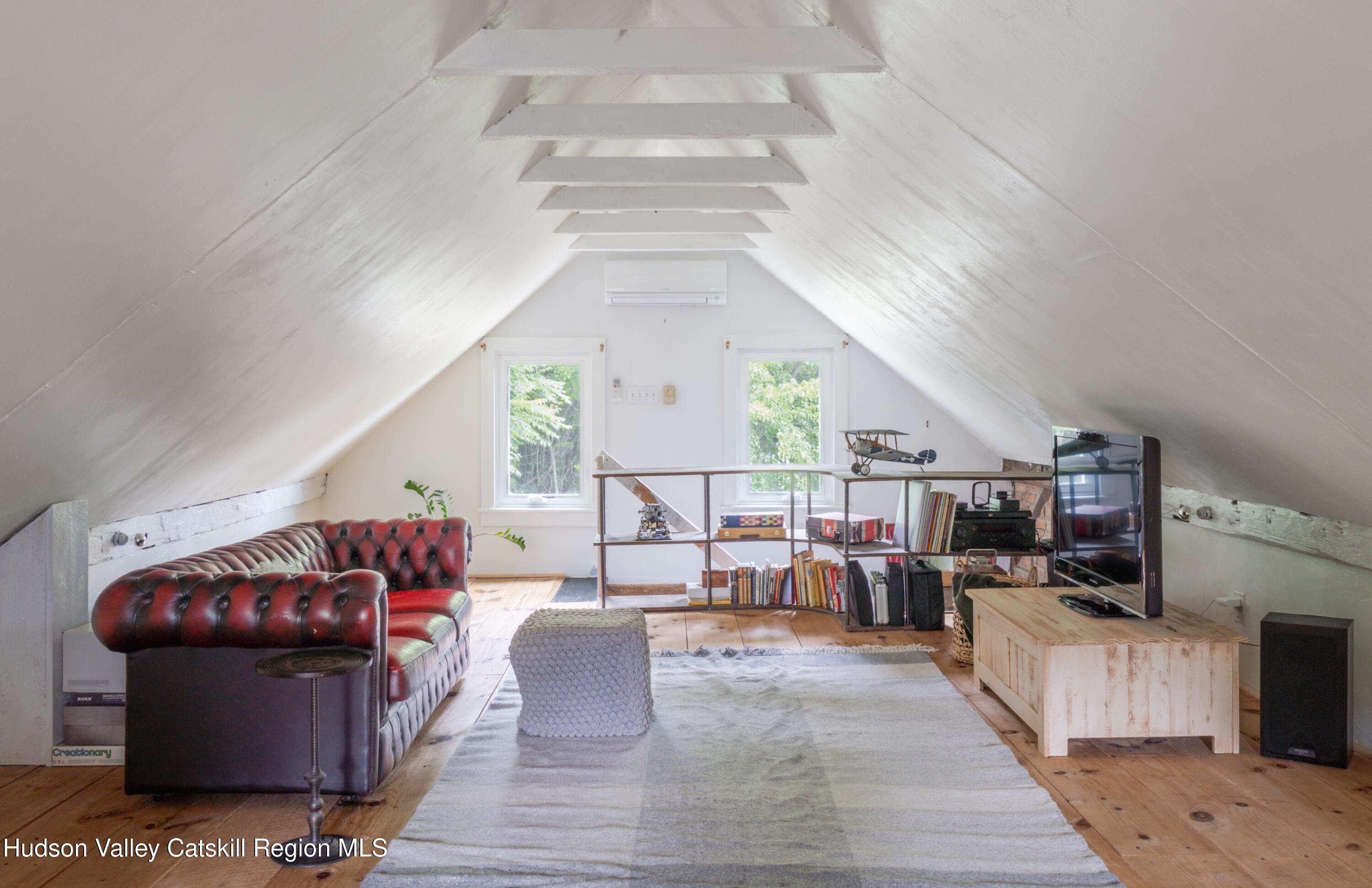 99 Spoorenburgh Road Athens, NY 12015 - Photo 25 of 39 a living room with furniture a flat screen tv and a floor to ceiling window