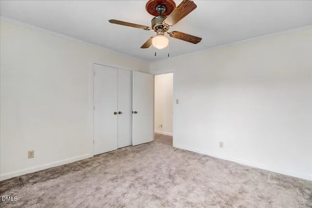 an empty room with a chandelier fan and a ceiling fan
