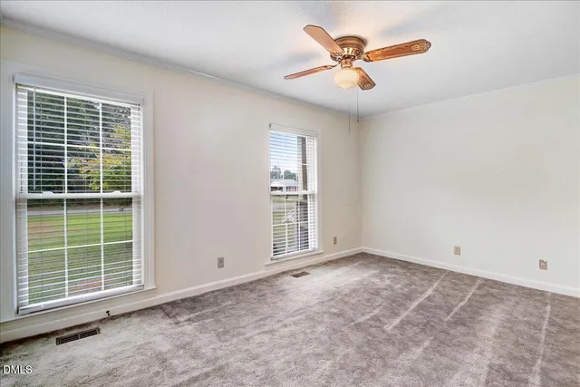 an empty room with window and a ceiling fan