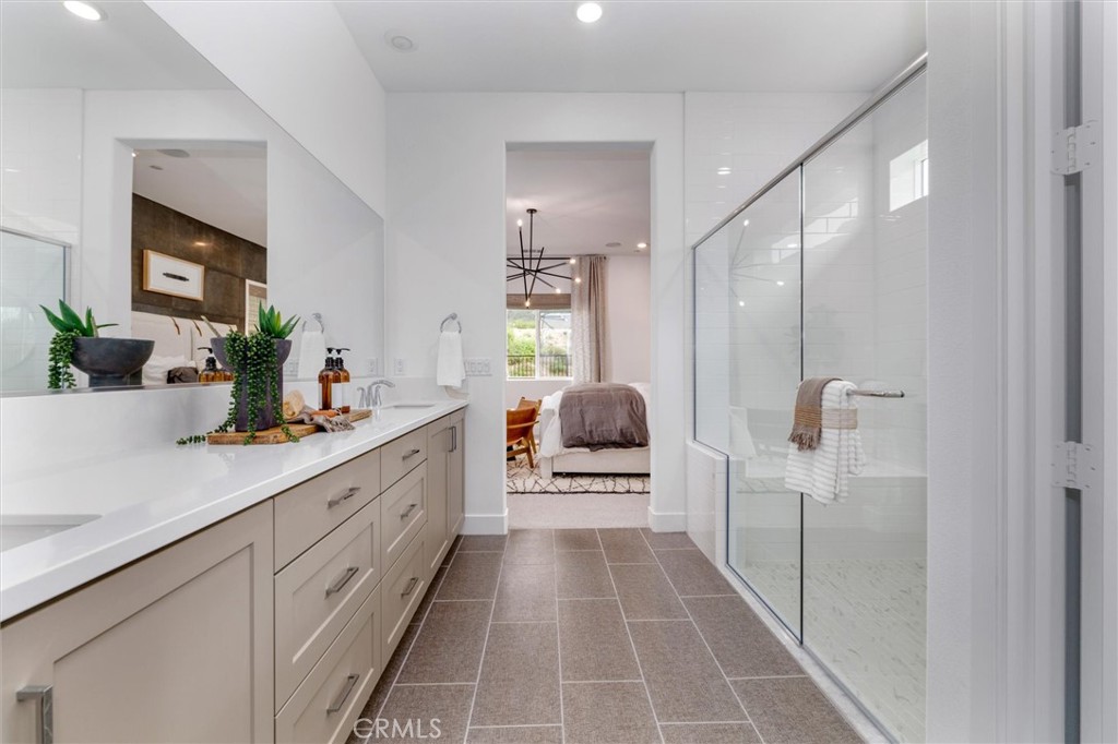 29606 Paseo Capilla Valencia, CA 91354 - Photo 16 of 26 a en suite bathroom with a double vanity sink and a mirror