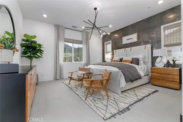 a bedroom with a large bed and a potted plant