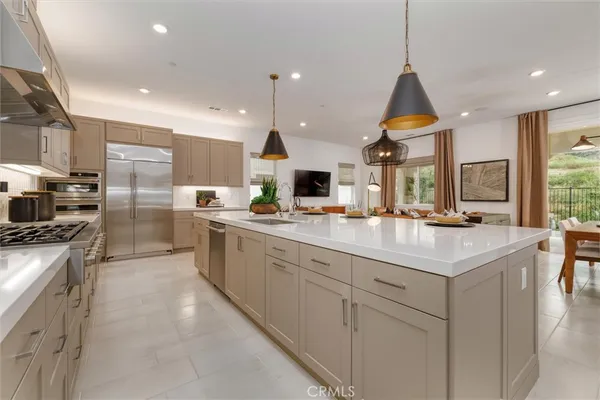 a kitchen with stainless steel appliances kitchen island granite countertop a sink and a refrigerator