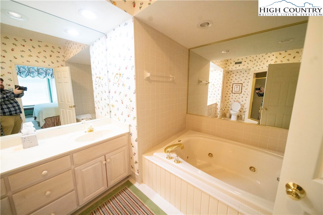 185 Waterside Drive, Unit 20 OF WALNUT 5 Blowing Rock, NC 28605 - Photo 11 of 15 a bathroom with a granite countertop tub sink shower and mirror