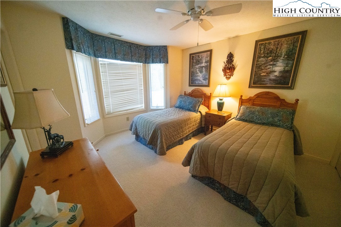 185 Waterside Drive, Unit 20 OF WALNUT 5 Blowing Rock, NC 28605 - Photo 13 of 15 a bedroom with two beds and a large mirror next to a window