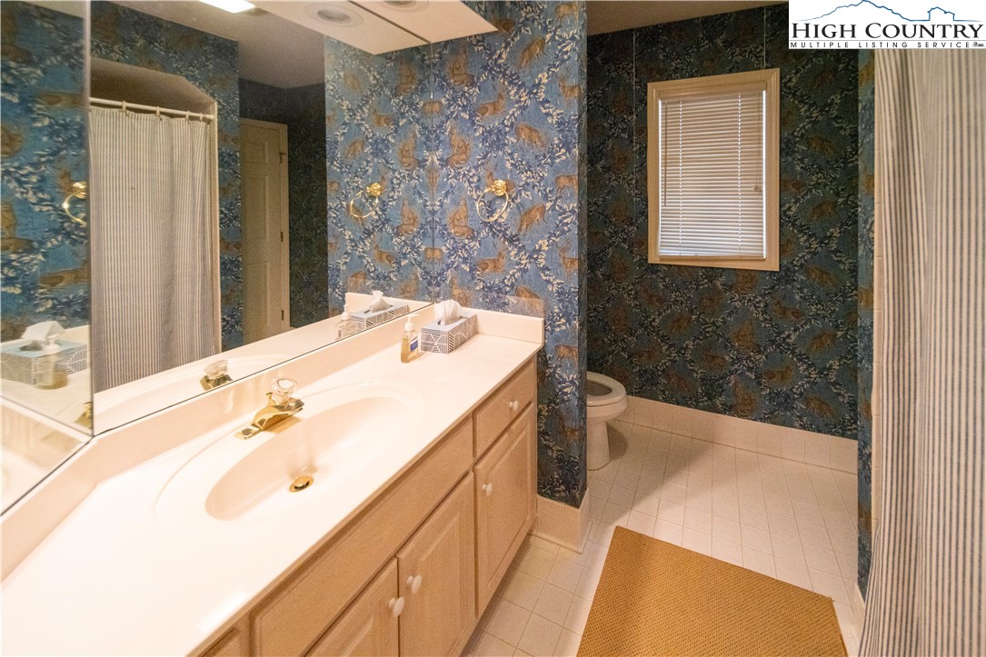 185 Waterside Drive, Unit 20 OF WALNUT 5 Blowing Rock, NC 28605 - Photo 14 of 15 a spacious bathroom with a granite countertop sink a toilet a mirror and shower