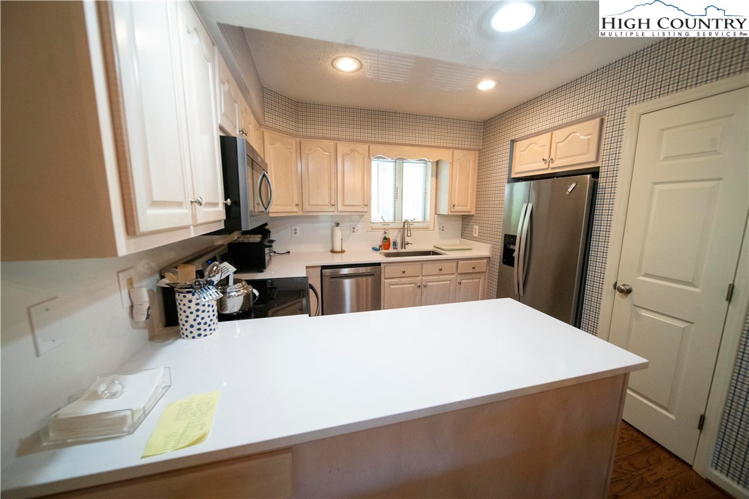185 Waterside Drive, Unit 20 OF WALNUT 5 Blowing Rock, NC 28605 - Photo 5 of 15 a kitchen with a refrigerator a sink a stove and cabinets