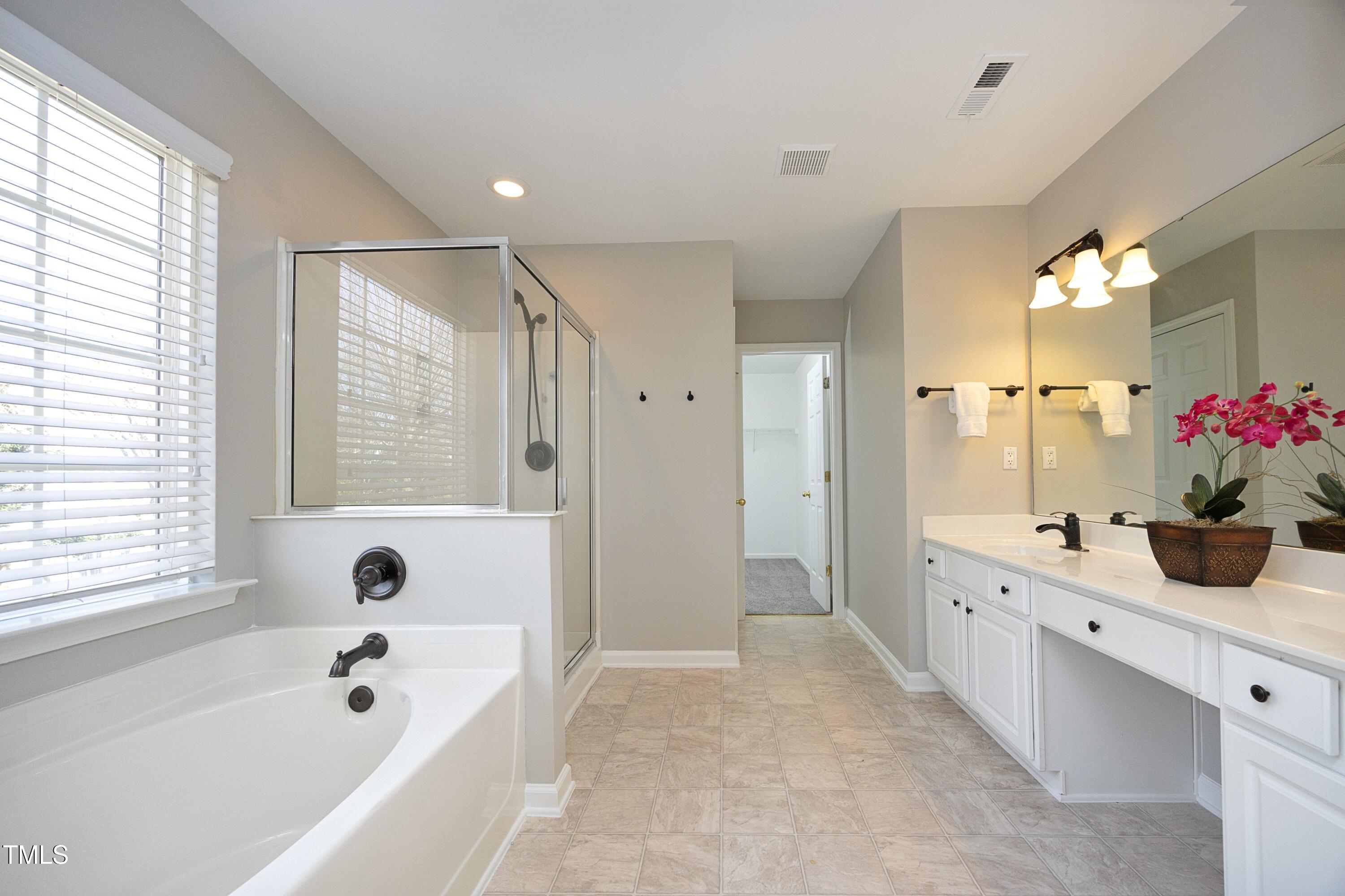 1525 Nealstone Way Raleigh, NC 27614 - Photo 25 of 47 a bathroom with a tub sink shower and two mirror
