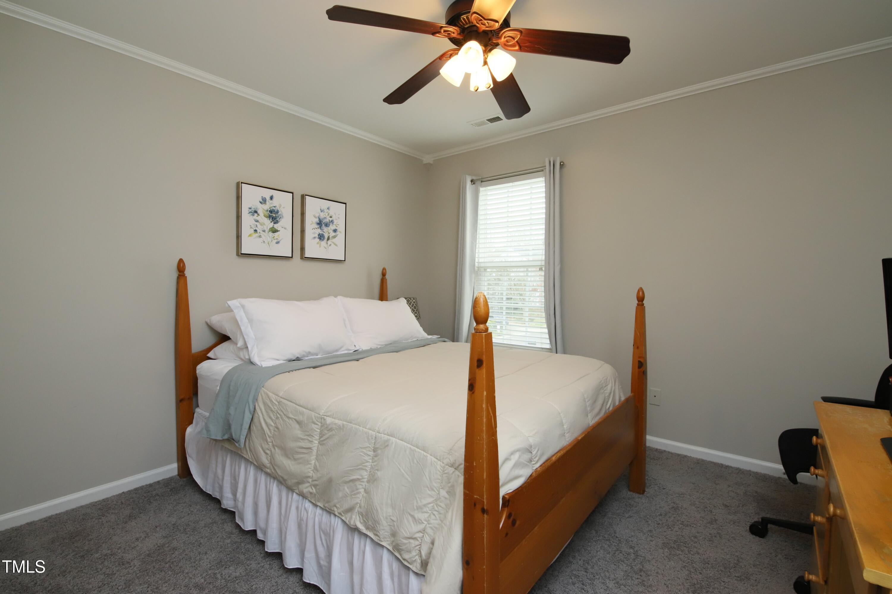 1525 Nealstone Way Raleigh, NC 27614 - Photo 34 of 47 a bed room with a bed and a chandelier