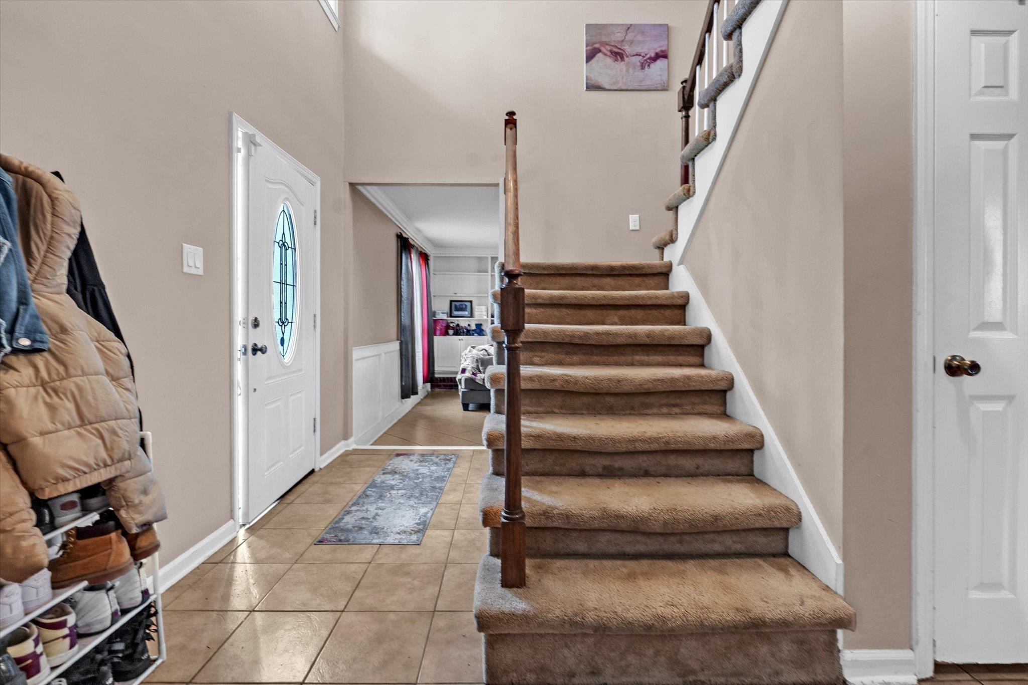 480 Friars Point Lane Memphis, TN 38018 - Photo 14 of 26 Foyer featuring light tile patterned flooring, wainscoting, and a high ceiling