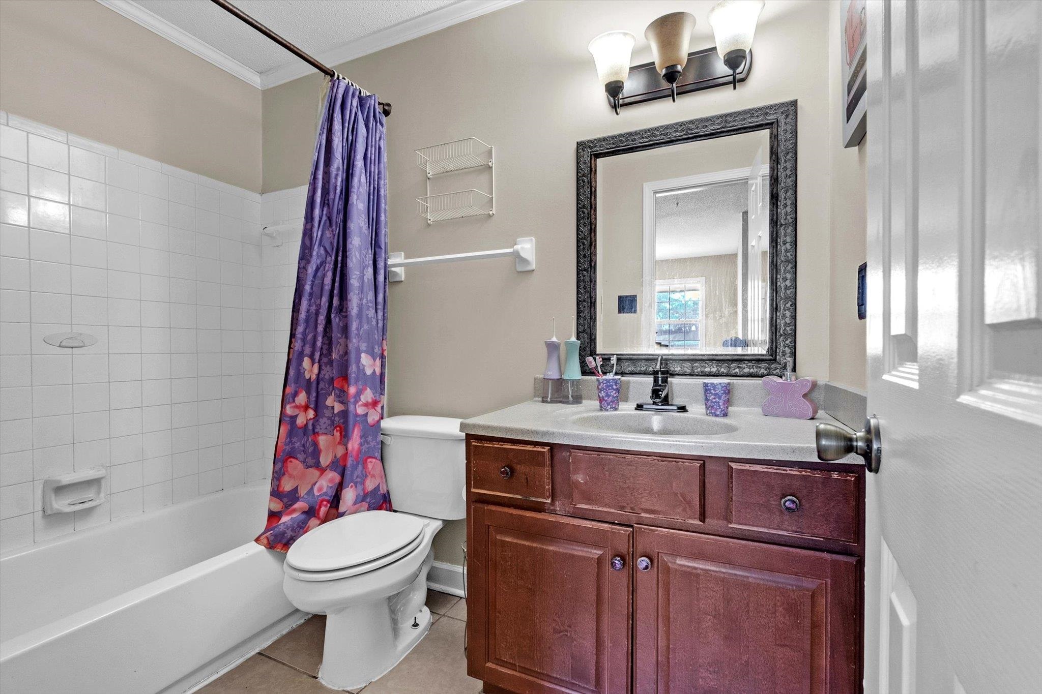 480 Friars Point Lane Memphis, TN 38018 - Photo 20 of 26 Bathroom featuring vanity, light tile patterned floors, shower / bath combination with curtain, and crown molding