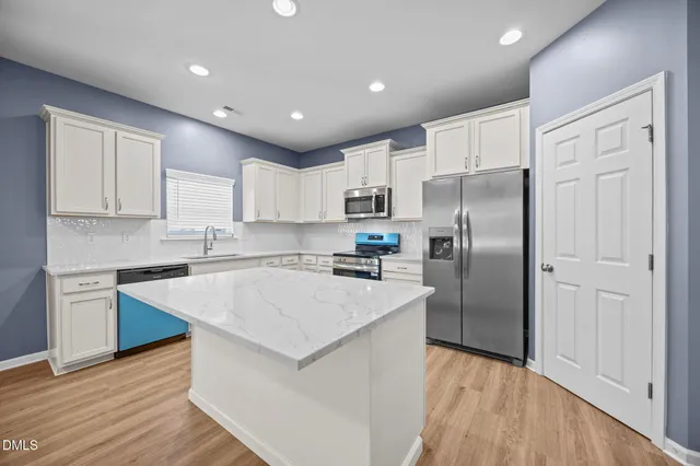 a kitchen with a refrigerator a sink and cabinets
