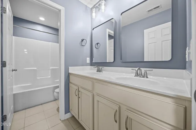 a bathroom with a granite countertop sink a mirror and a bathtub