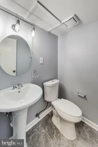 a bathroom with a sink toilet and mirror