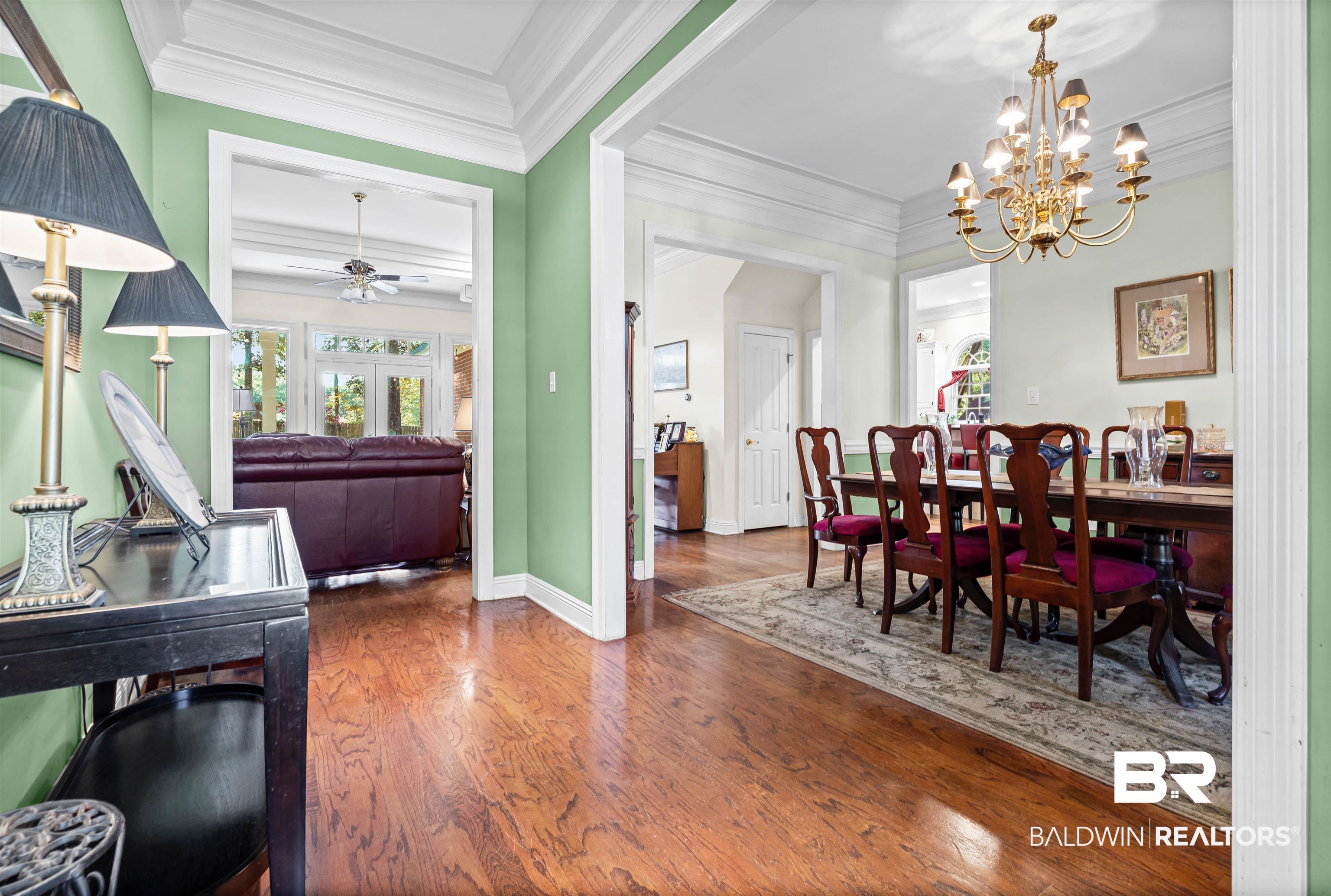 107 Beaver Dam Road Fairhope, AL 36532 - Photo 15 of 45 Dining space featuring crown molding, dark wood-type flooring, a chandelier, and a ceiling fan