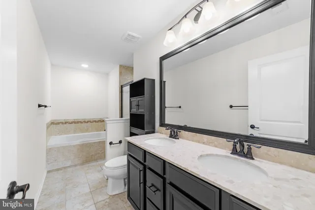 a bathroom with a granite countertop sink mirror and bathtub
