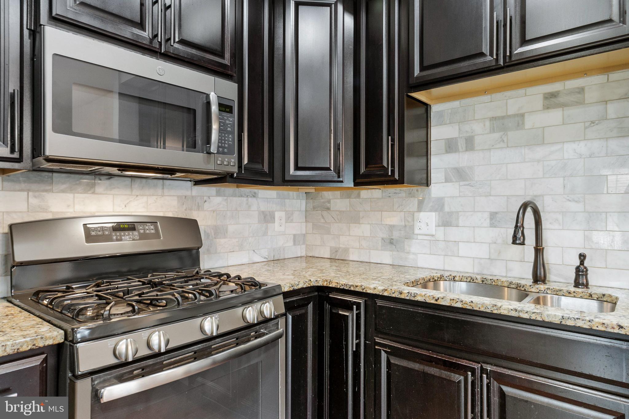 42 Sundance Drive Hamilton, NJ 08619 - Photo 9 of 25 a kitchen with granite countertop a stove and a microwave