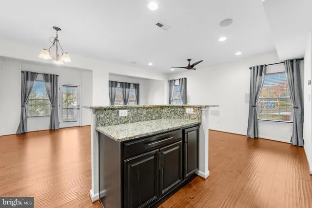 a kitchen with granite countertop a stove and a wooden floors