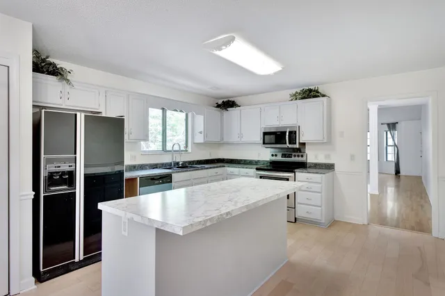 a kitchen with white cabinets and stainless steel appliances